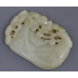 A Chinese pale celadon jade plaque, carved and pierced with a pine bough and prunus, 6.2cm