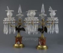 A pair of French Empire style gilt bronze and ormolu candelabra, with cut glass spires and sconces