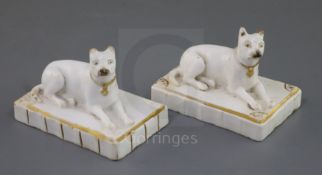 Two Rockingham porcelain figures of terriers, c.1830, each recumbent on a fluted rectangular base,