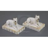 Two Rockingham porcelain figures of terriers, c.1830, each recumbent on a fluted rectangular base,