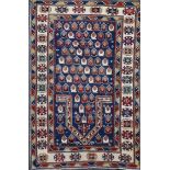 A Caucasian blue ground prayer rug, the central mihrab with field of geometric motifs and three