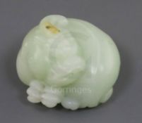A Chinese celadon jade carving of a lion-dog, in recumbent pose its crest with a russet inclusion,
