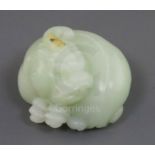 A Chinese celadon jade carving of a lion-dog, in recumbent pose its crest with a russet inclusion,