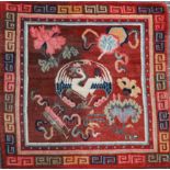 A Tibetan square sitting rug, late 19th/early 20th century, woven with a crane and auspicious