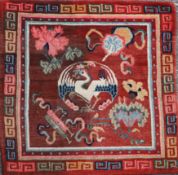 A Tibetan square sitting rug, late 19th/early 20th century, woven with a crane and auspicious