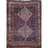 A Qashgai blue ground rug, with two central hooked diamond shaped motifs in a geometric field, 7ft