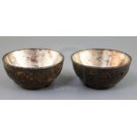 A pair of Chinese coconut bowls, 18th century, each carved in relief with flower roundels and