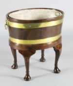 A George III brass bound staved mahogany wine cooler, with zinc liner and lion mask handles, with