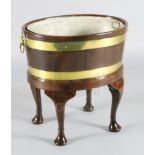 A George III brass bound staved mahogany wine cooler, with zinc liner and lion mask handles, with