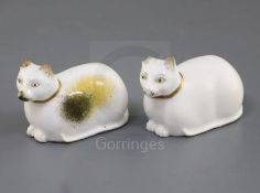 Two Rockingham porcelain figures of a recumbent cat, c.1830, in white and tortoiseshell markings,