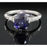 A mid 20th century platinum? and single stone oval synthetic sapphire ring, with diamond set