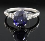 A mid 20th century platinum? and single stone oval synthetic sapphire ring, with diamond set