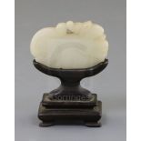 A Chinese white jade 'lion-dog' plaque, 18th century, the stone of good even tone with tiny