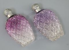 A pair of late Victorian silver lidded amethyst tinted cut glass scent flasks, of baluster form, C.