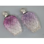 A pair of late Victorian silver lidded amethyst tinted cut glass scent flasks, of baluster form, C.