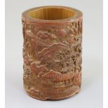 A Chinese bamboo brush pot, carved in high relief and openwork with figures and pavilions in a