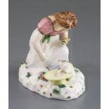 A Rockingham porcelain group of a kneeling girl playing with a kitten, c.1830, impressed mark '