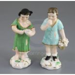 A pair of Rockingham porcelain figures of a beggar boy and girl, c.1830, the boy holding a basket of