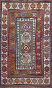 An antique Caucasian polychrome ground rug, with four central octagon and a multi row geometric