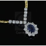 An 18ct two colour gold, sapphire and diamond oval cluster pendant necklace, 42cm
