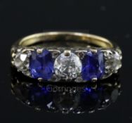 An early 20th century 18ct gold, graduated two stone sapphire and three stone diamond half hoop