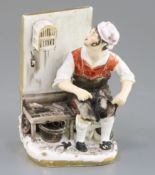 A Rockingham porcelain figure of a seated cobbler, c.1830, the figure whistling to a bird in a cage,