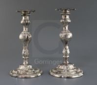A pair of late George II embossed silver candlesticks, by William Tuite, with inverted pear shaped