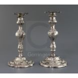A pair of late George II embossed silver candlesticks, by William Tuite, with inverted pear shaped