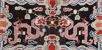A Tibetan 'dragon' khaden rug, early 20th century, woven with two confronting dragons chasing a