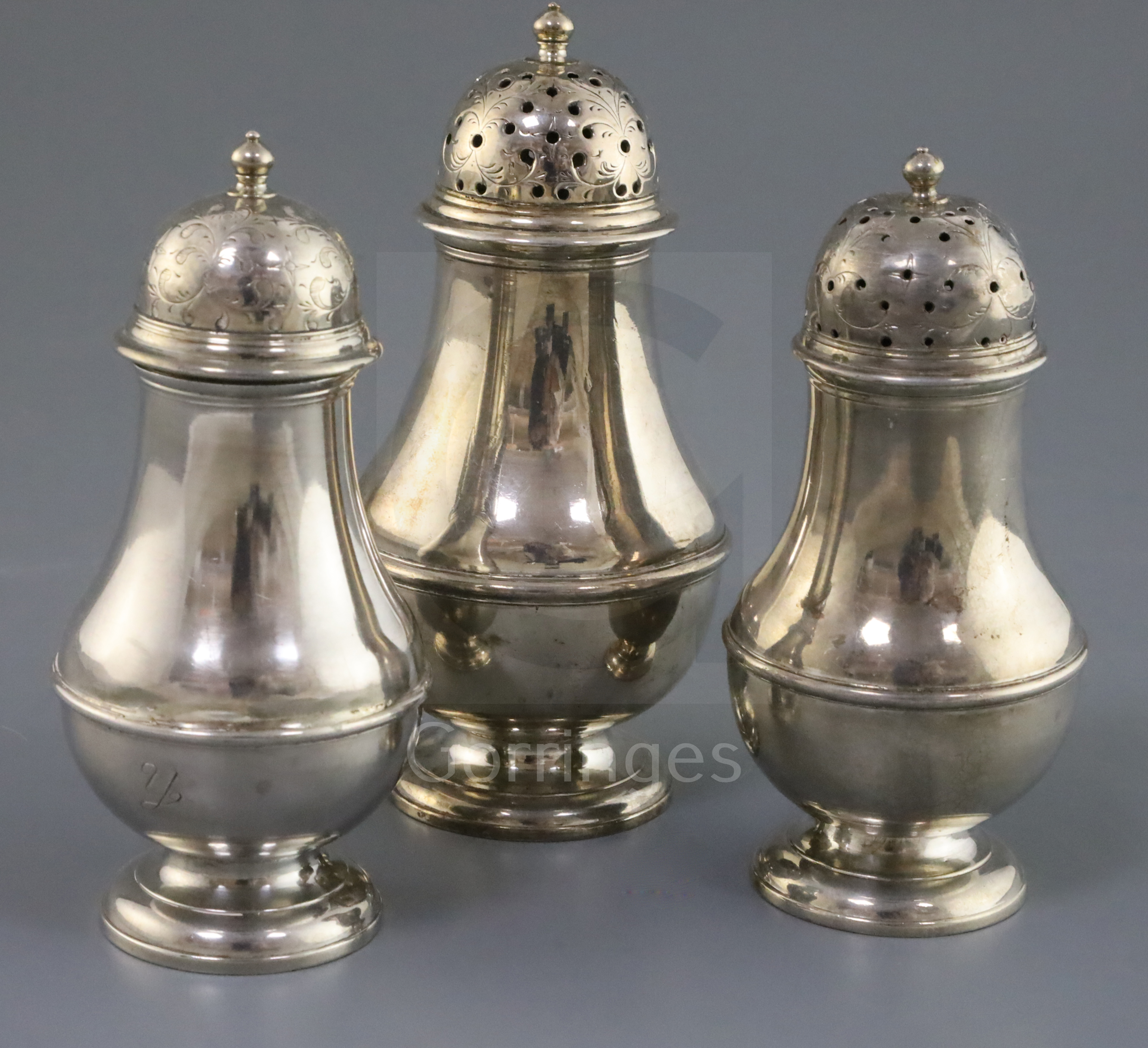 A suite of three early George II Scottish silver baluster pepperettes by James Mitchelson I,