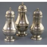 A suite of three early George II Scottish silver baluster pepperettes by James Mitchelson I,