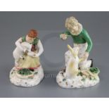 A pair of Rockingham porcelain groups of a boy feeding a rabbit and a girl seated with a lamb, c.