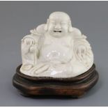 A Chinese blanc-de-chine figure of Budai, 19th century, seated and holding a peach in his right