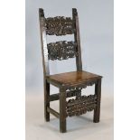 A 17th century Spanish carved walnut side chair, decorated with foliate motifs, with solid seat