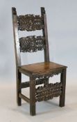 A 17th century Spanish carved walnut side chair, decorated with foliate motifs, with solid seat