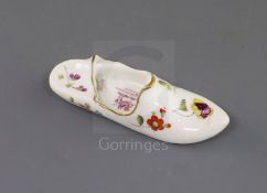 A Rockingham porcelain model of a slipper, c.1830-42, painted with flower sprays, the interior of