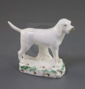 A Rockingham porcelain figure of a foxhound, c.1830, on a naturalistic oblong base enamelled with