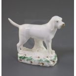 A Rockingham porcelain figure of a foxhound, c.1830, on a naturalistic oblong base enamelled with