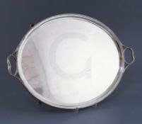 A George V silver oval two handled tea tray by Thomas Bradbury & Sons, with beaded border and