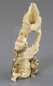 A Japanese ivory okimono of a Yamabushi Tengu, Meiji period, blowing on a conch shell, a monkey at