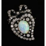 A Victorian gold and silver, white opal and diamond heart shaped brooch, with tied ribbon