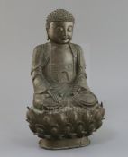 A Chinese bronze seated figure of Buddha Shakyamuni, 17th century, with tightly knotted hair, flower
