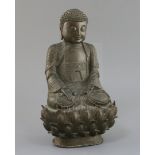 A Chinese bronze seated figure of Buddha Shakyamuni, 17th century, with tightly knotted hair, flower