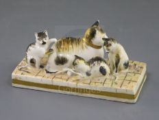 A Rockingham porcelain group of a cat and three kittens, c.1830, with tabby markings, on a paved