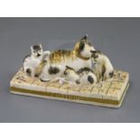 A Rockingham porcelain group of a cat and three kittens, c.1830, with tabby markings, on a paved