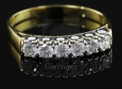 A modern 18ct gold and six stone diamond half hoop ring, size W/X.