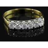 A modern 18ct gold and six stone diamond half hoop ring, size W/X.