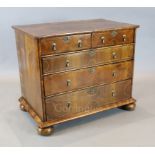 An early 18th century inlaid walnut chest of two short and three graduated long drawers, on bun