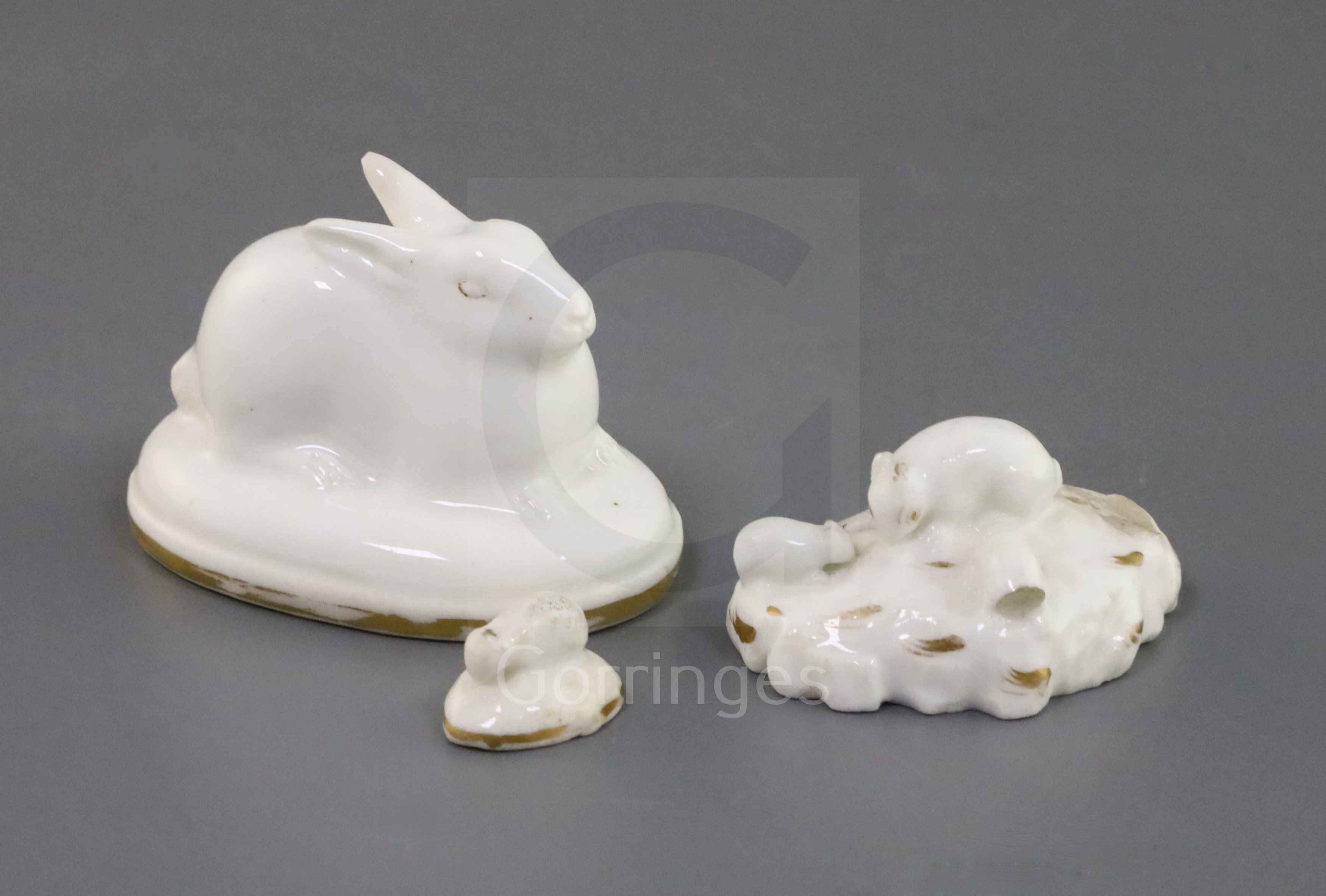 A Rockingham porcelain figure of a hare and two toy groups of rabbits, c.1830, all decorated in gilt