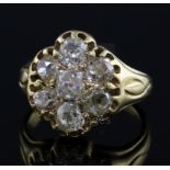 An early-mid 20th century gold and seven stone diamond cluster ring, set with old mine cut stones,